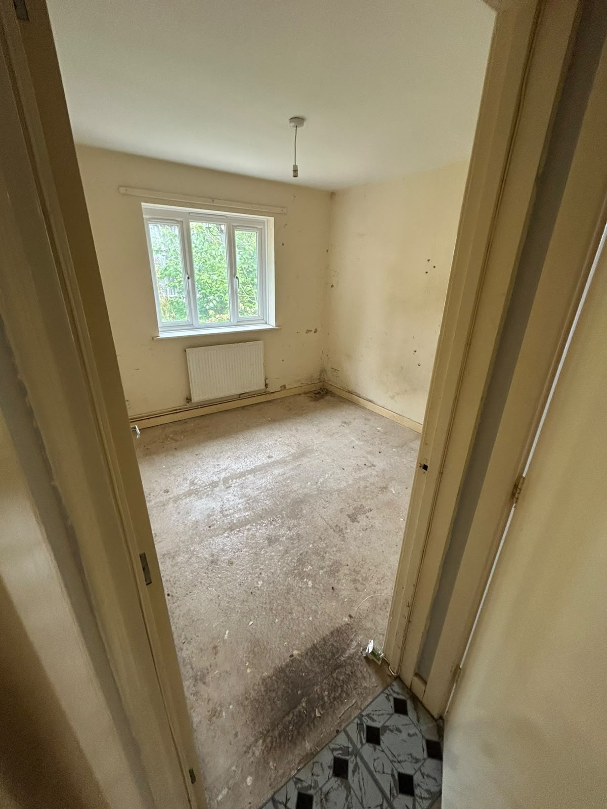 Worn Manchester room cleared to bare floorboards during a probate house clearance
