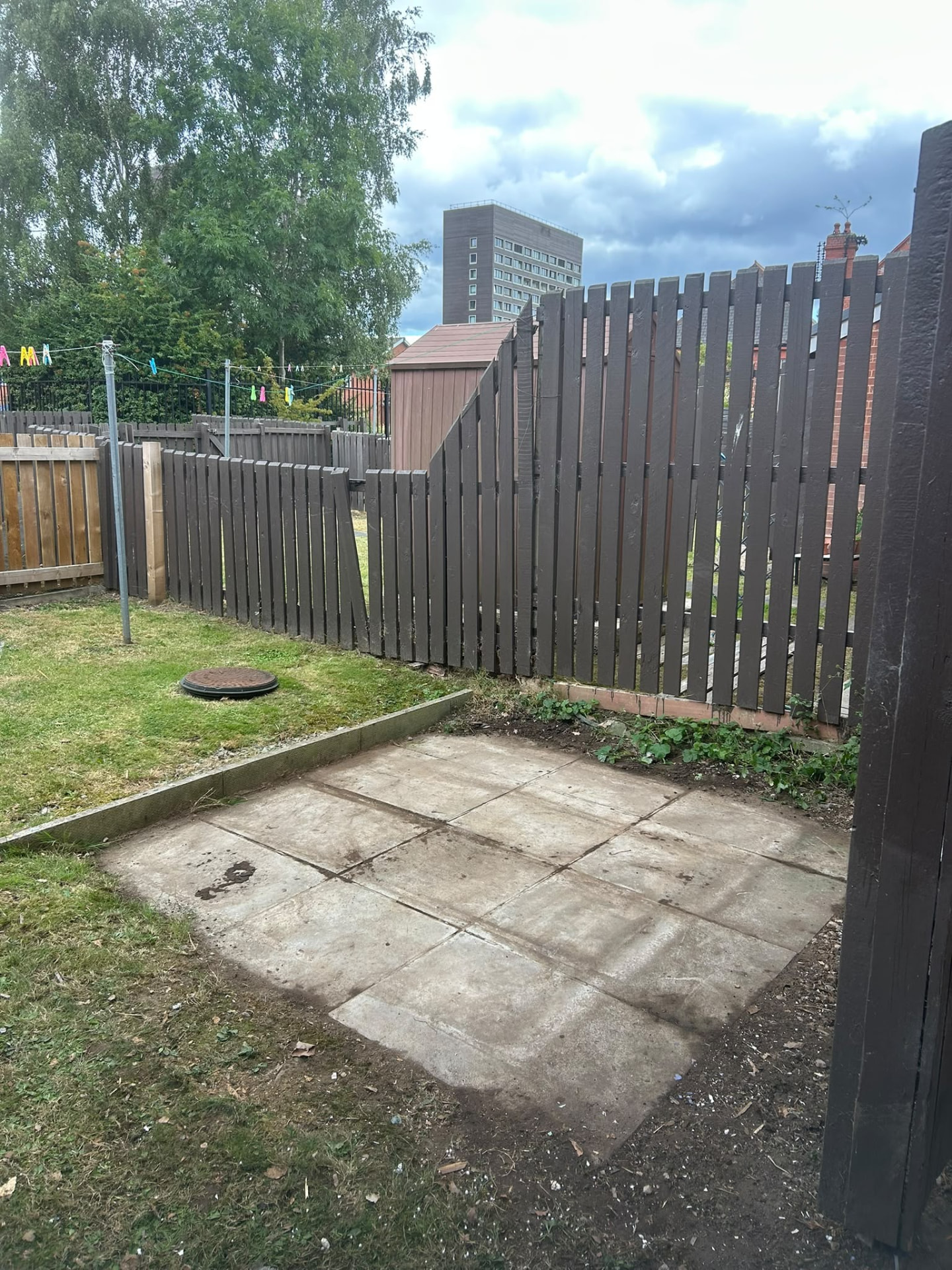 Paved Manchester garden cleared of green waste with tidy grass borders and clean fencing