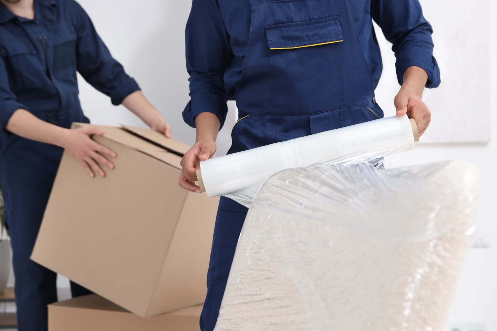 Operatives wrapping a single mattress and carrying a box for a single item collection