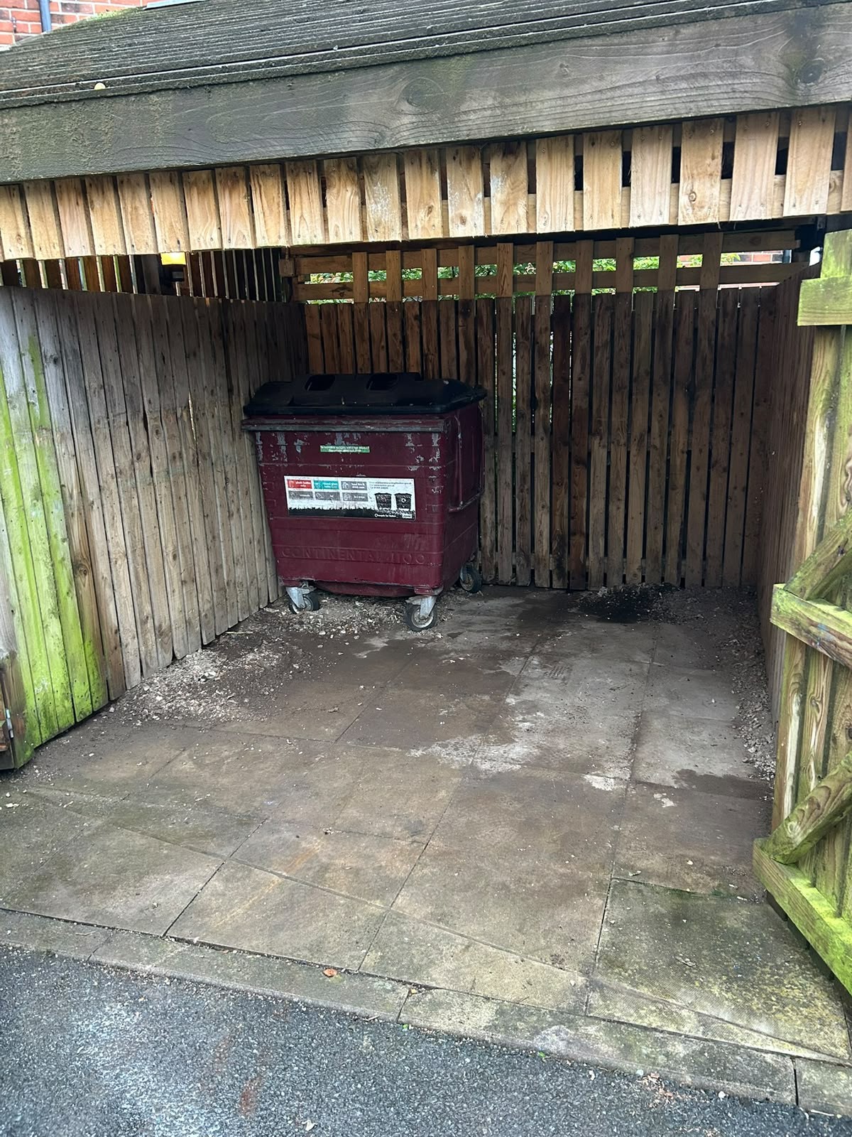 Bin shelter in Manchester emptied to bare concrete with one wheelie bin remaining after clearance