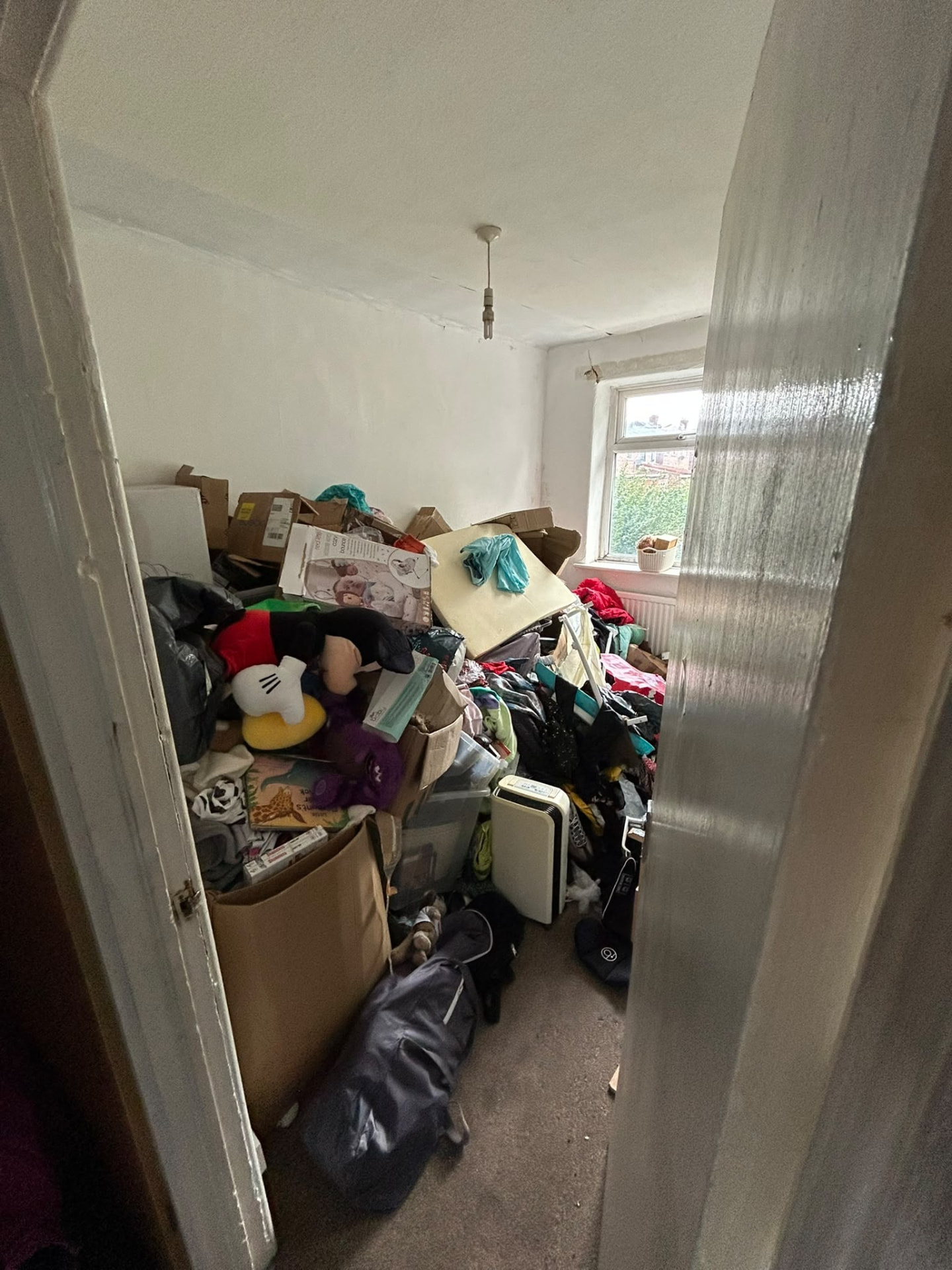 Room in a Manchester property packed floor to ceiling with belongings before a large property clearance