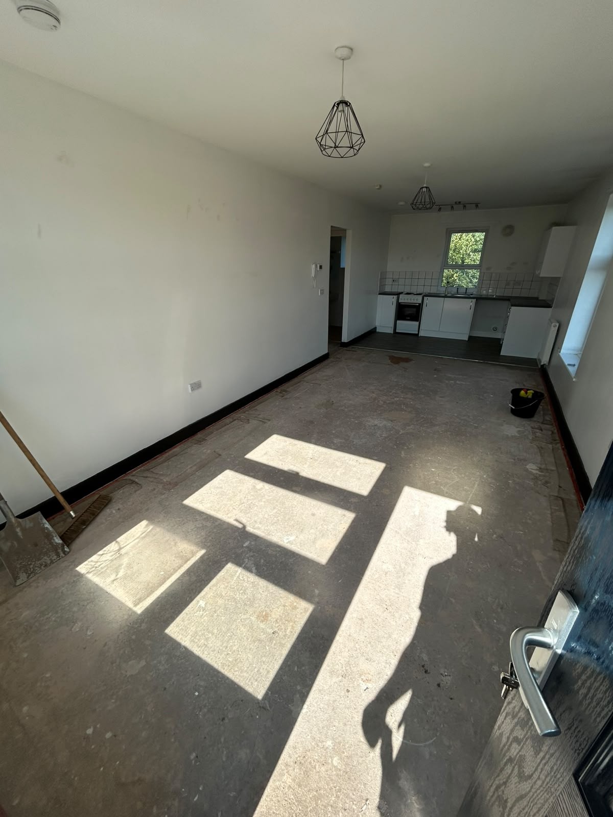 Open-plan Manchester living and kitchen area fully cleared and swept after a house clearance