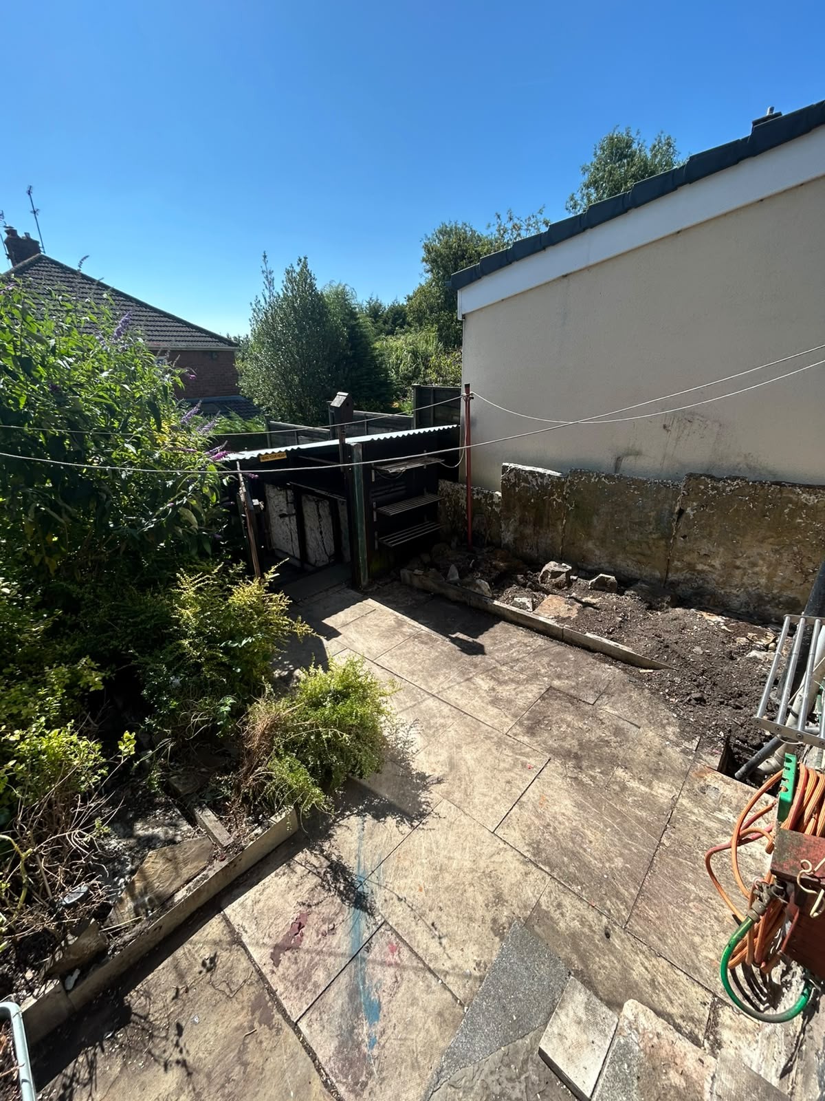 Manchester rear patio part stripped out, with old boundary walling broken down for removal